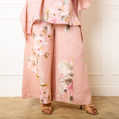 The dusky pink Bouquet Print Linen Trousers in a wide leg silhouette with pockets on either side